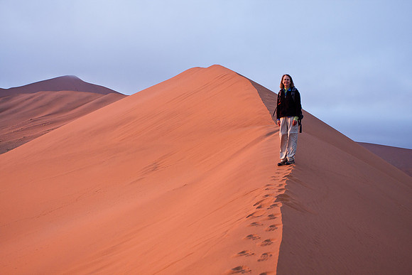 Jane, climbing dune at sunrise